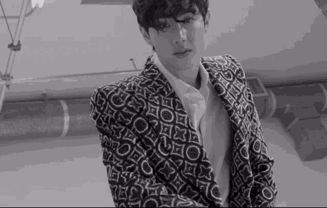 a black and white photo of a man wearing a louis vuitton suit jacket