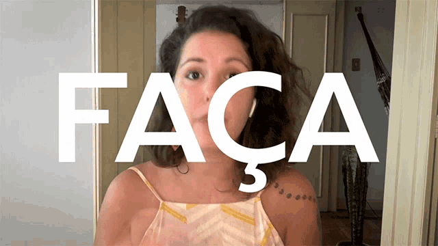a woman stands in front of a sign that says " faca "
