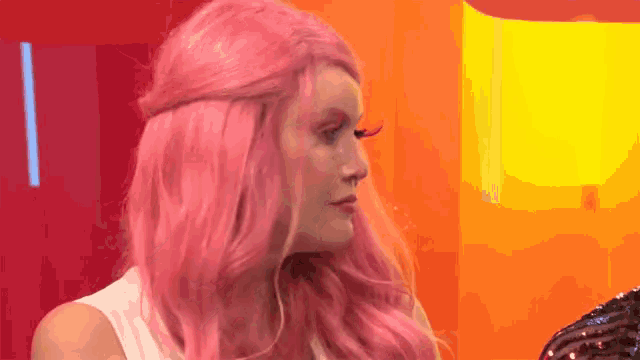 a woman with pink hair and red eye lashes
