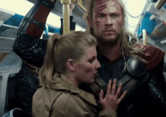 a man in a superhero costume holds a woman 's hand