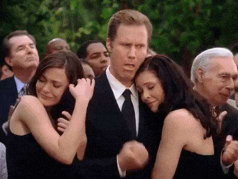 a group of people are standing around a man in a suit .