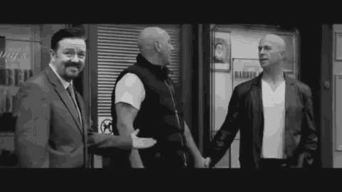 a black and white photo of three men standing next to each other in front of a building holding hands .