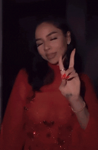 a woman in a red dress with red nails is dancing .
