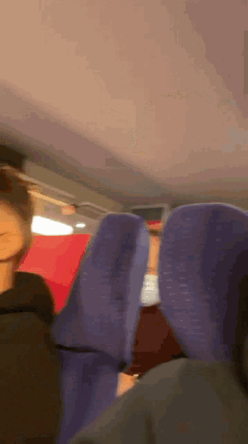 a blurry picture of a person sitting in a blue seat