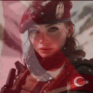 a woman in a red beret is holding a gun and wearing a red scarf .
