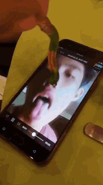 a phone with a picture of a man sticking his tongue out on the screen