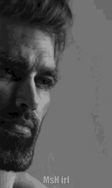 a black and white photo of a man with a beard and the words `` msh irl '' on the bottom .