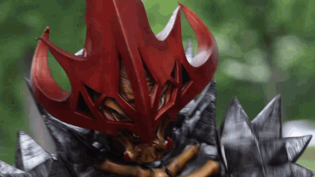 a close up of a person wearing a red and black mask
