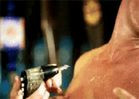 a man is getting a tattoo on his chest with a needle
