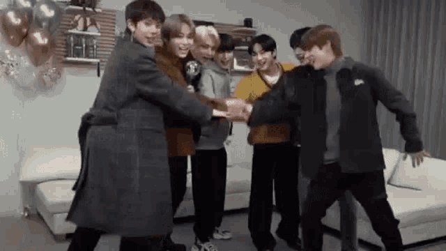 a group of young men are standing in a living room .