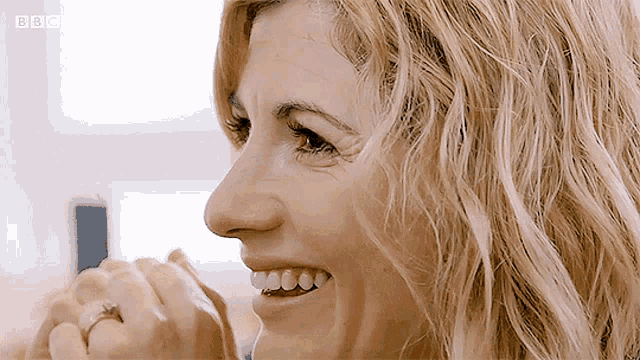 a close up of a woman 's face with the bbc logo in the background