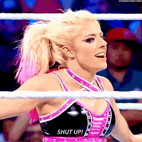 a woman in a wrestling ring with the word shut up on her top
