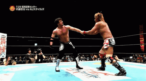 two wrestlers are fighting in a ring with a sign that says ' a j styles ' on it