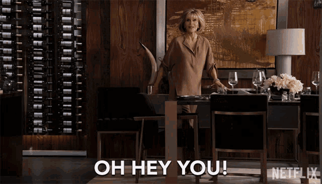 a woman standing at a table with the words oh hey you