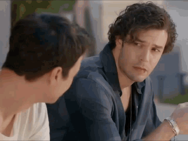two men are talking to each other and one has a bracelet on his wrist