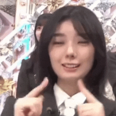 a woman in a suit is giving a thumbs up sign .