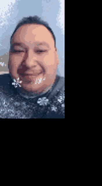 a man with a beard is smiling for the camera while wearing a black sweater .