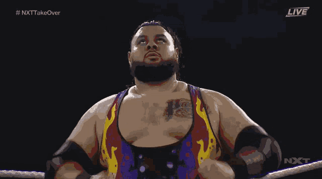 a wrestler is standing in a ring with the words live on the bottom