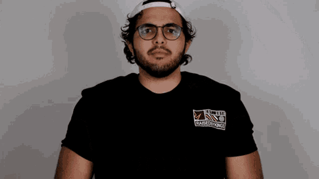 a man wearing glasses and a black t-shirt that says barbershop on it