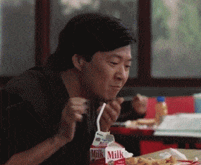 a man eating a meal with a carton of milk in front of him