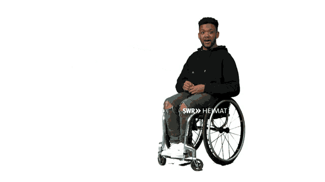 a man in a wheelchair is pointing at something with swr written on the bottom