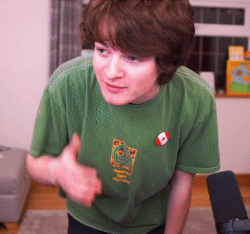a young man wearing a green shirt with a canadian flag pin on it