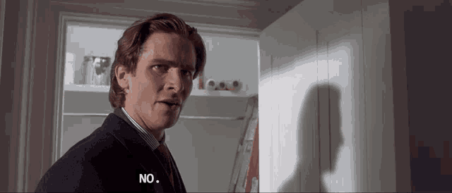 a man in a suit and tie says no in a room
