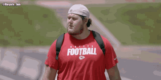 a man wearing a red shirt that says " football "