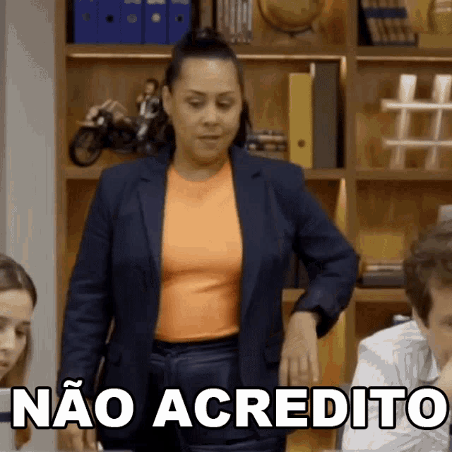 a woman in a suit stands in front of a group of people and says nao acredita