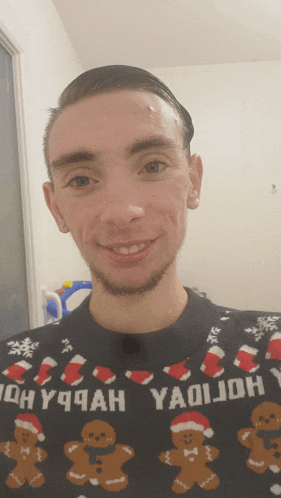 a man wearing a sweater with gingerbread men and the word yaoijoh on it