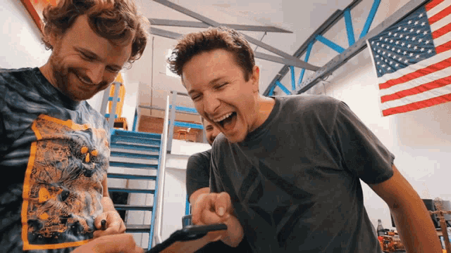 a man wearing a tie dye shirt is laughing with another man