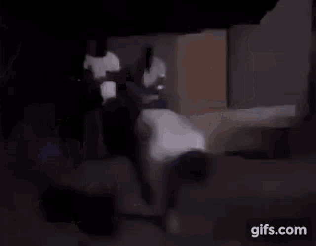 a group of people are standing next to each other in a dark room in a blurry photo .