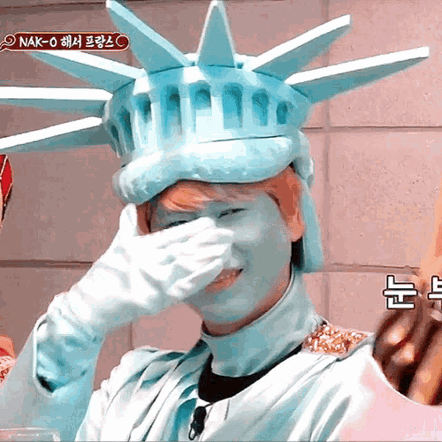 a man in a statue of liberty costume is covering his face