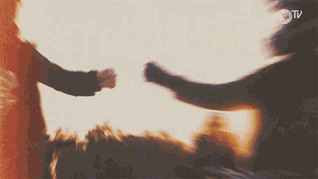 a blurred image of two people holding hands with a red bull tv logo in the corner