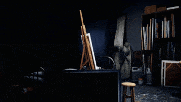 a dark room with a bed and an easel with a painting on it