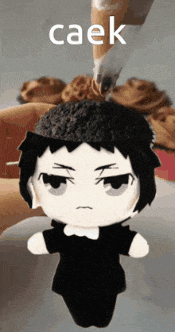 a person is holding a stuffed doll with the word caek on it
