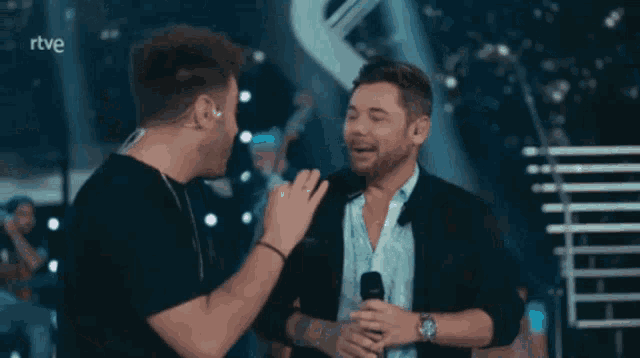 two men on a stage with the word rtve on the bottom