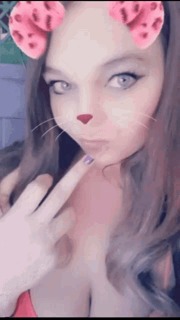 a woman wearing a cat face mask with hearts on it