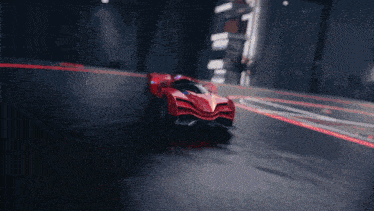 a red sports car is driving down a track in a dark room