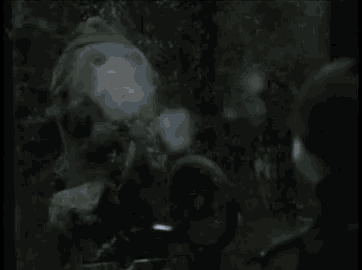 a man is standing in front of a statue of a monkey in a dark forest .