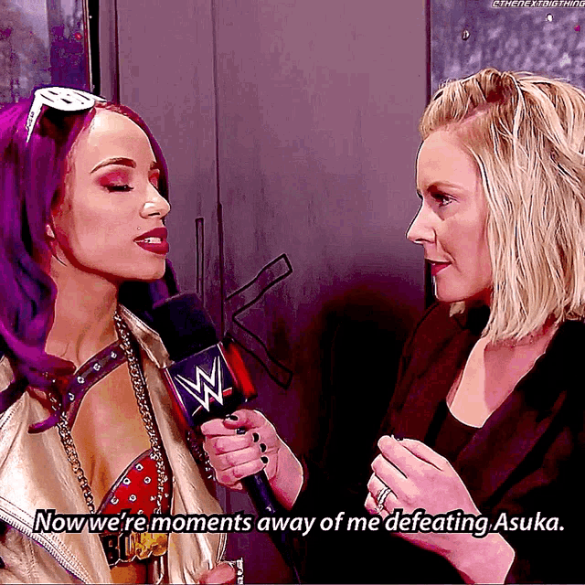 a woman with purple hair is talking to another woman