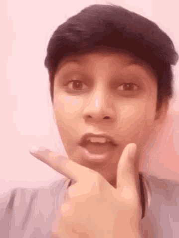 a young man is making a funny face with his hand