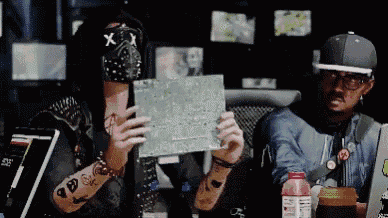 a man wearing a mask with an x on it holds a piece of paper