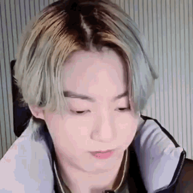 a close up of a person 's face with their eyes closed and a necklace around their neck .