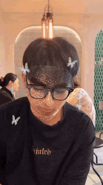 a person wearing glasses and a shirt that says tinted on it