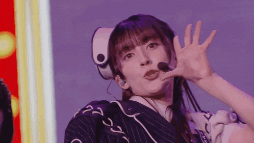 a woman wearing headphones and a headband is making a funny face .