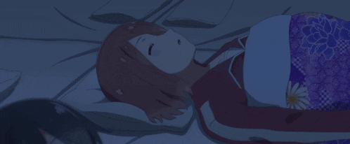 a girl laying on a bed with a purple blanket