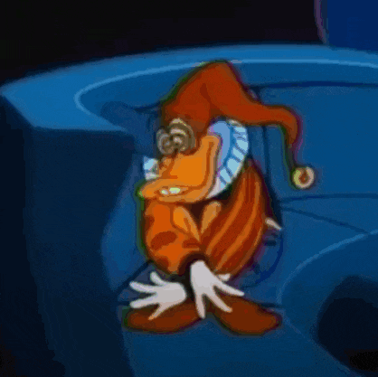 a cartoon character wearing a jester hat is sitting on a blue surface .