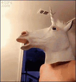 a person is wearing a unicorn mask with their mouth open .