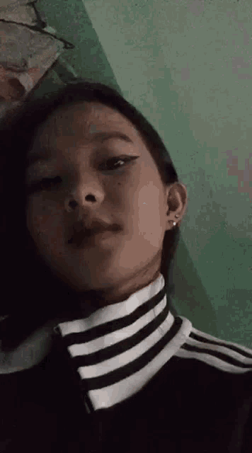a close up of a girl wearing a black and white striped turtleneck sweater .